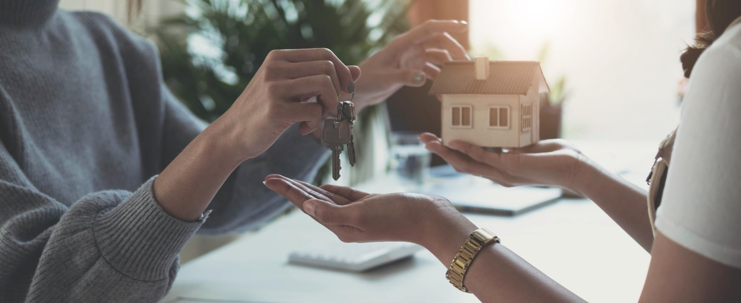 Agent immobilier donnant des clés de la maison à la femme et signer un accord au bureau