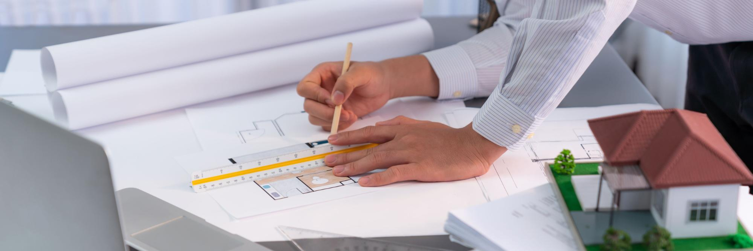 Architecte d'intérieur à la table de conception dessine les plans d'une maison